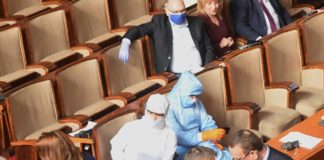 Марешки и заместничката му със защитни костюми и скафандри в парламента