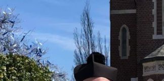 Свещеник пръска светена вода с воден пистолет, за да спази дистанцията